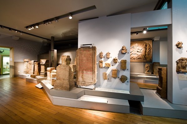 Various stone altars and artefacts on display in a museum